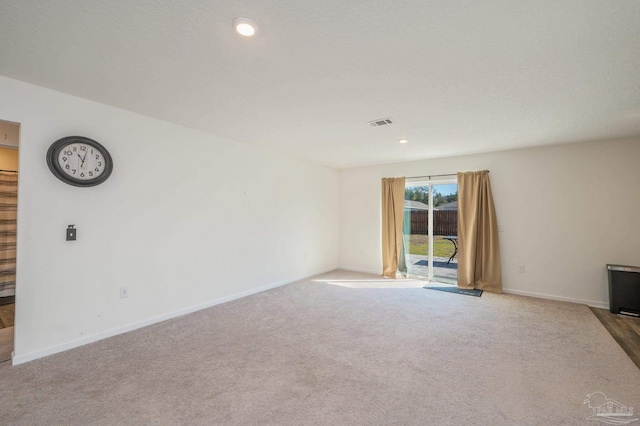 unfurnished living room featuring recessed lighting, light colored carpet, visible vents, and baseboards