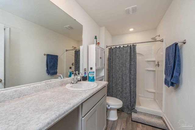 full bathroom with visible vents, toilet, a shower stall, vanity, and wood finished floors