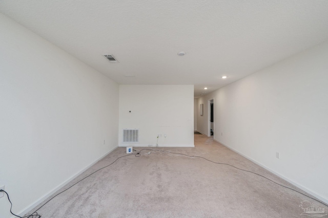 empty room with light carpet, recessed lighting, visible vents, and baseboards