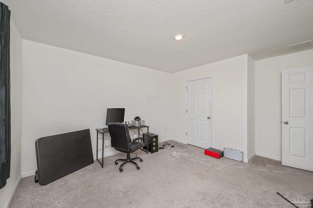 home office with light colored carpet, a textured ceiling, and baseboards