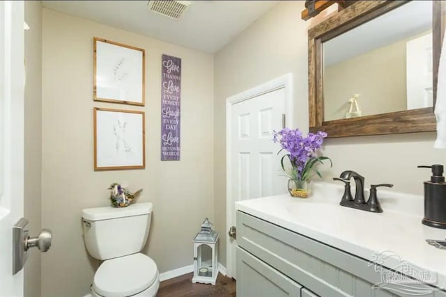 bathroom featuring toilet, hardwood / wood-style floors, and vanity