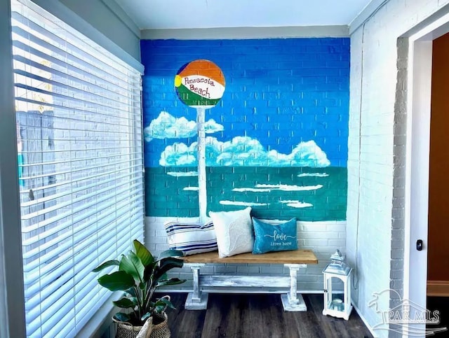 mudroom featuring brick wall and wood-type flooring