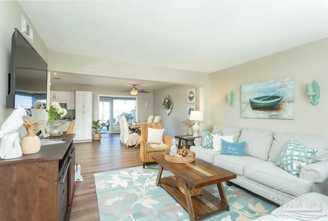 living room featuring ceiling fan and dark hardwood / wood-style floors