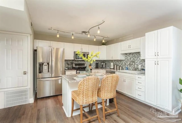 kitchen featuring stainless steel appliances, a kitchen island, white cabinets, and sink