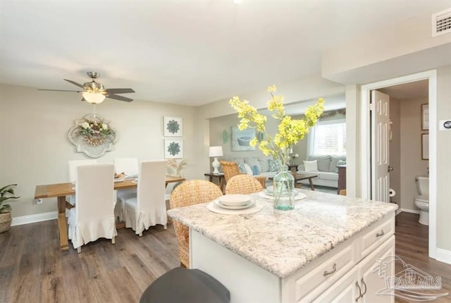 kitchen featuring white cabinets, ceiling fan, dark hardwood / wood-style floors, and a kitchen island