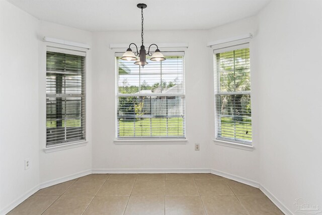 4803 Jaimee Leigh Dr, Milton, FL 32570 - unfurnished dining area with a chandelier, light tile patterned floors, and baseboards