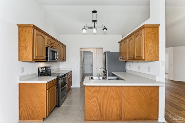 4803 Jaimee Leigh Dr, Milton, FL 32570 - kitchen featuring appliances with stainless steel finishes, a sink, a peninsula, light countertops, and brown cabinets