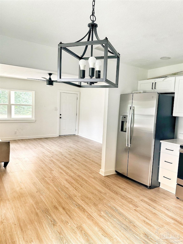 kitchen with ceiling fan, decorative light fixtures, stainless steel fridge with ice dispenser, light hardwood / wood-style floors, and white cabinetry