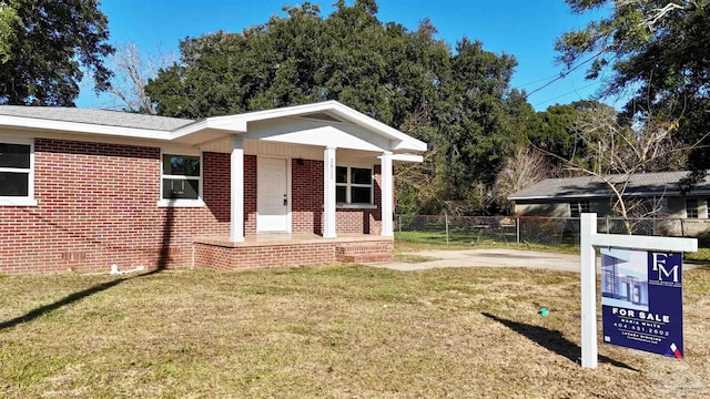 view of front of house featuring covered porch and a front yard