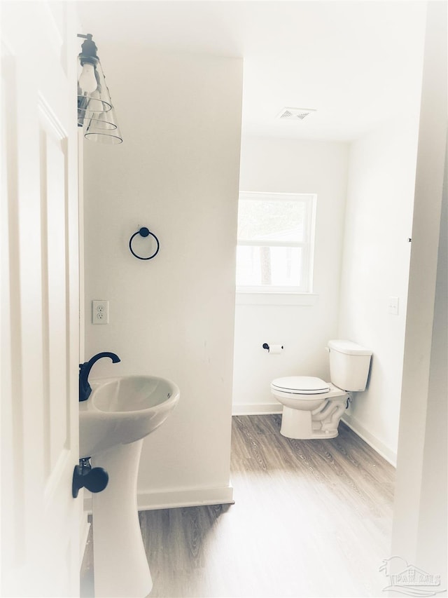 bathroom featuring hardwood / wood-style flooring and toilet