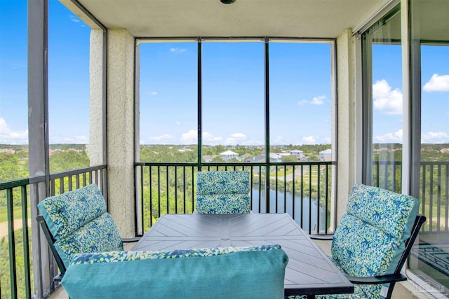 sunroom / solarium featuring a water view