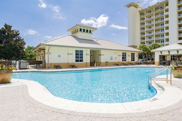 community pool featuring a patio and fence