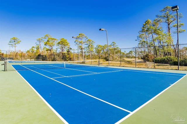 view of tennis court with fence and community basketball court