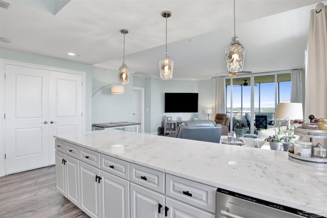 kitchen featuring light wood finished floors, white cabinets, dishwasher, light stone countertops, and pendant lighting