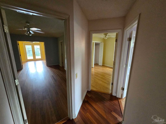 hallway with dark wood-type flooring and french doors