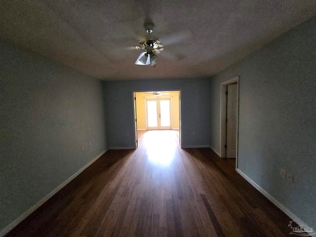 spare room featuring french doors, ceiling fan, dark wood-type flooring, and a textured ceiling