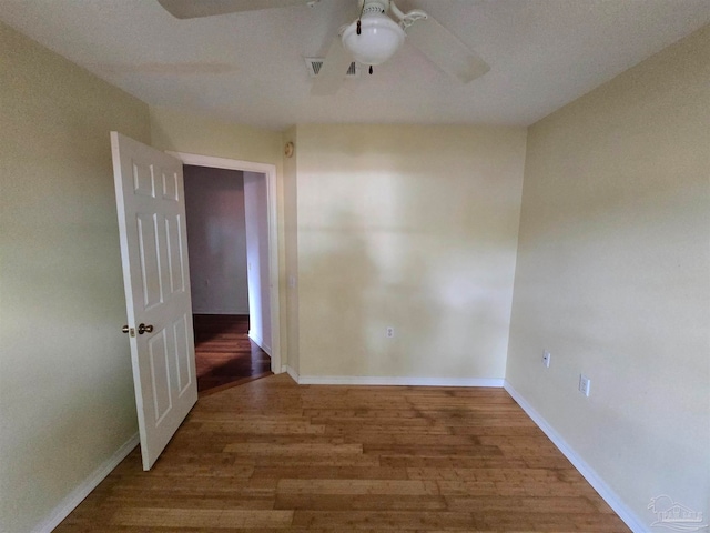 spare room with ceiling fan and wood-type flooring