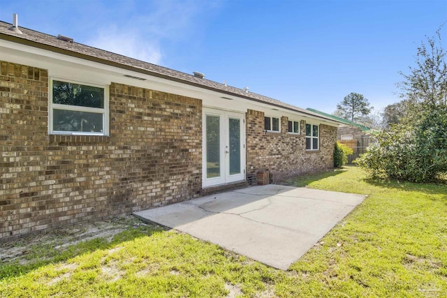 back of property featuring a lawn, fence, french doors, a patio area, and brick siding