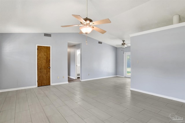 empty room with lofted ceiling, visible vents, and baseboards