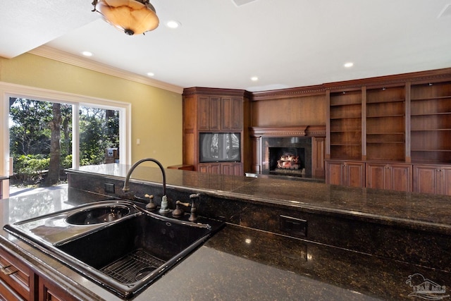721 W Miracle Strip Pkwy, Mary Esther, FL 32569 - kitchen featuring recessed lighting, crown molding, a lit fireplace, and a sink