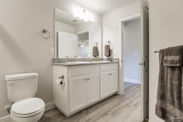 bathroom with a sink, visible vents, toilet, and wood finished floors