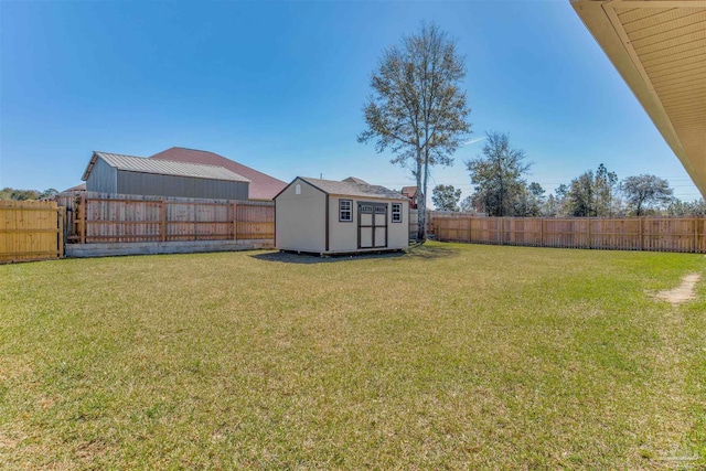 view of yard with a storage shed, a fenced backyard, and an outdoor structure