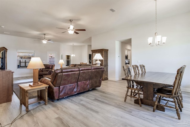 living room featuring visible vents, ceiling fan with notable chandelier, light wood-type flooring, and baseboards