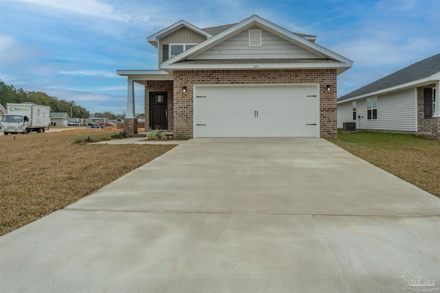 view of front of house featuring a garage, central air condition unit, and a front yard