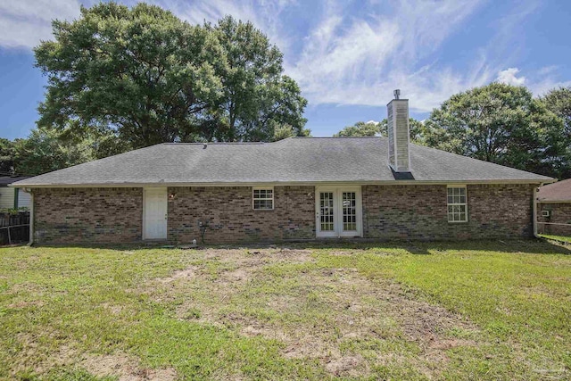 back of house featuring a lawn and french doors