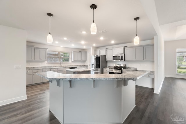 5619 Burr St, Milton, FL 32570 - kitchen with a kitchen breakfast bar, a large island, appliances with stainless steel finishes, a sink, and recessed lighting