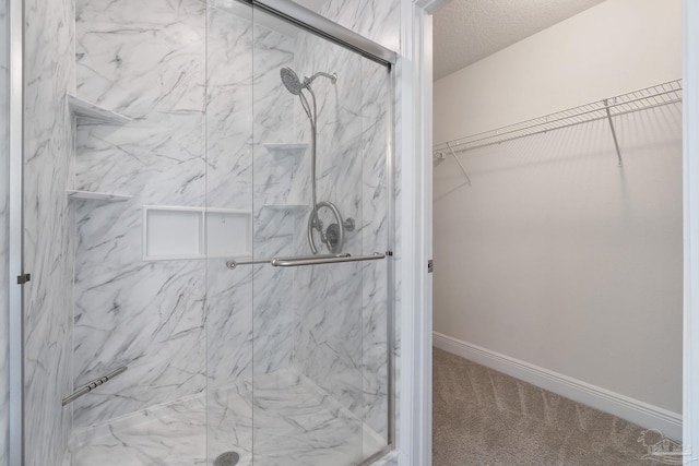 5619 Burr St, Milton, FL 32570 - bathroom featuring baseboards, a walk in closet, and a marble finish shower