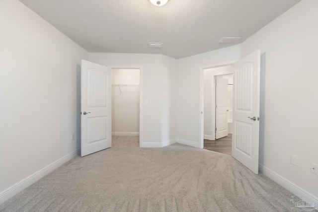 5619 Burr St, Milton, FL 32570 - unfurnished bedroom featuring a walk in closet, carpet floors, a textured ceiling, baseboards, and a closet