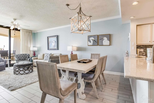 dining area with ceiling fan with notable chandelier, a textured ceiling, and ornamental molding