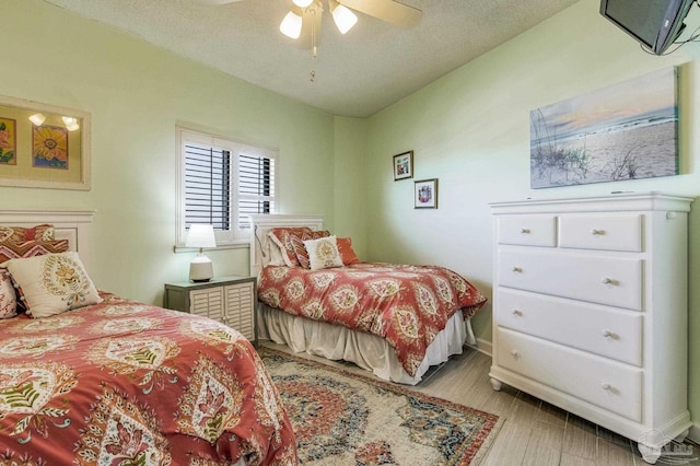 bedroom featuring ceiling fan, a textured ceiling, and light hardwood / wood-style flooring