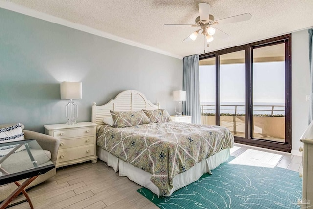 bedroom featuring expansive windows, access to outside, multiple windows, and ceiling fan