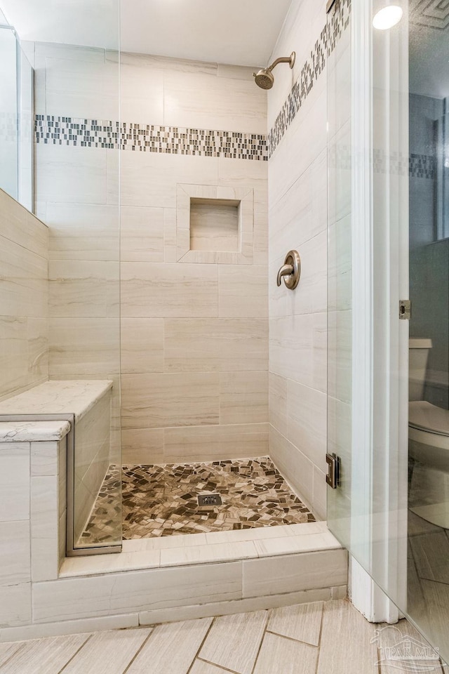 bathroom featuring an enclosed shower and toilet