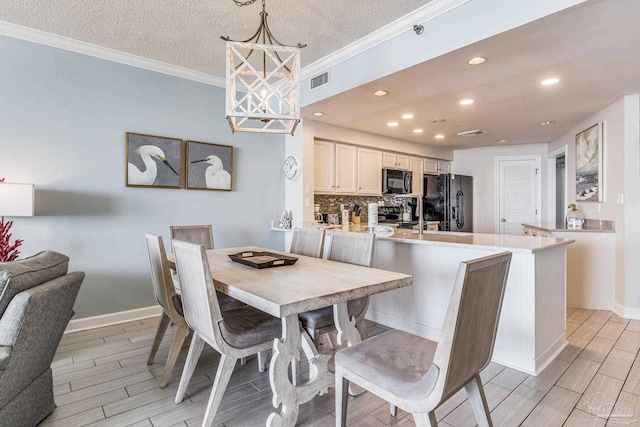 dining room featuring a textured ceiling and ornamental molding