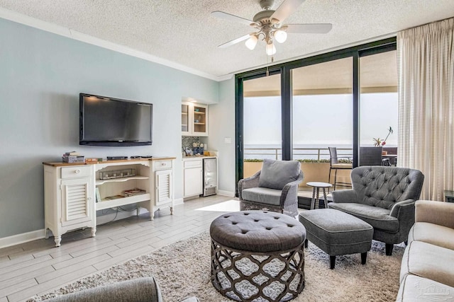 living room featuring floor to ceiling windows, beverage cooler, a healthy amount of sunlight, and a textured ceiling