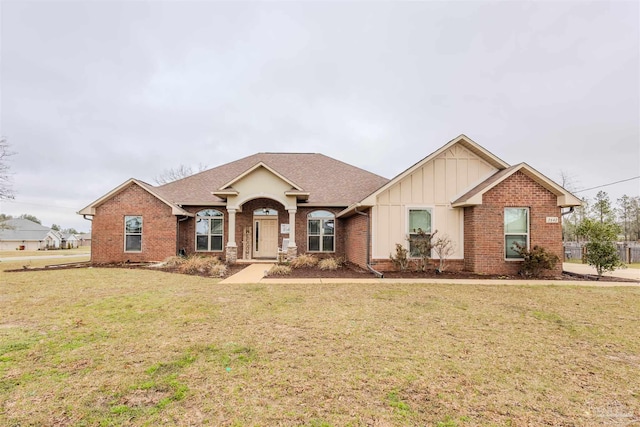 ranch-style home featuring brick siding, board and batten siding, a front yard, and a shingled roof