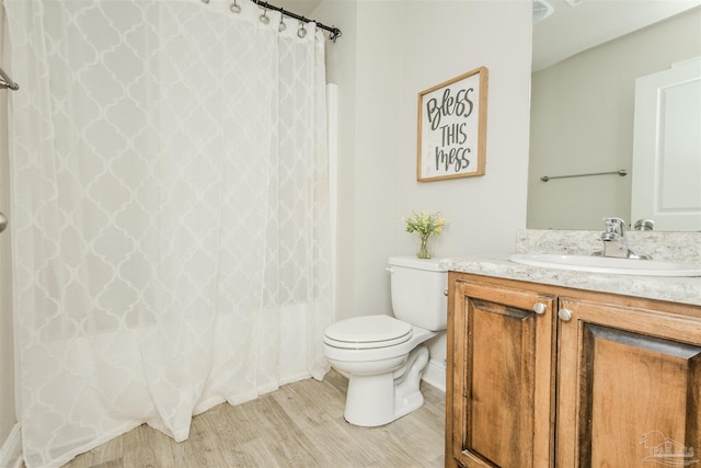 bathroom featuring a shower with curtain, vanity, toilet, and wood finished floors