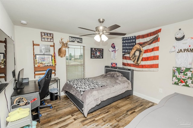 bedroom featuring wood finished floors, a ceiling fan, and baseboards