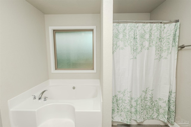 bathroom with curtained shower and a garden tub