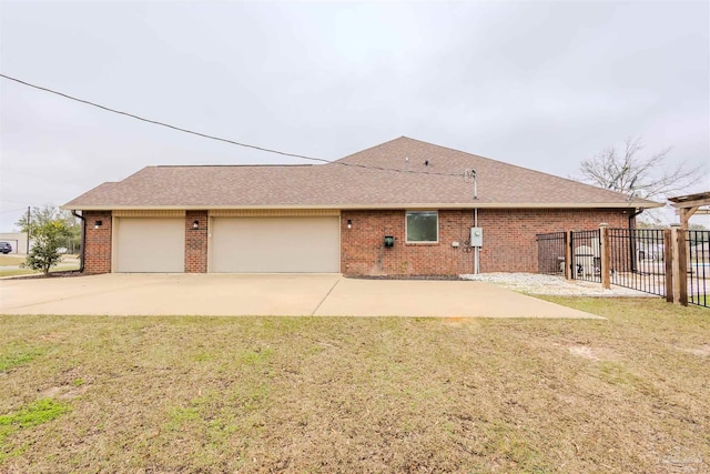 exterior space featuring brick siding, roof with shingles, an attached garage, fence, and a front lawn