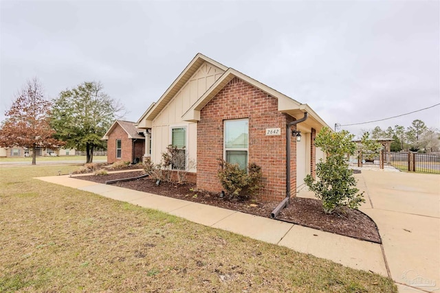 ranch-style house featuring board and batten siding, a front yard, brick siding, and fence