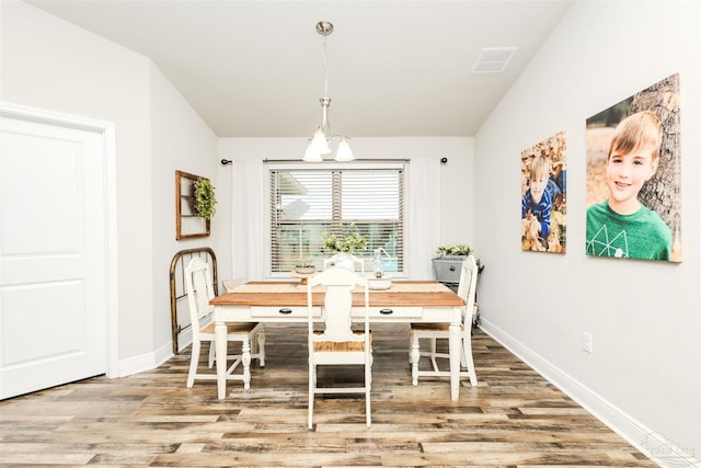 dining area with visible vents, baseboards, and wood finished floors