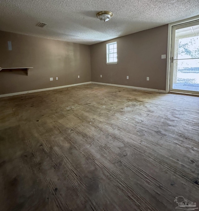 unfurnished room with a textured ceiling and hardwood / wood-style floors