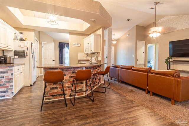 kitchen with white cabinetry, kitchen peninsula, and dark hardwood / wood-style floors