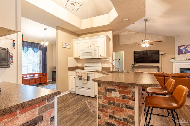 kitchen with ceiling fan with notable chandelier, white appliances, white cabinets, and dark hardwood / wood-style floors