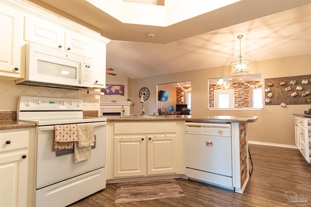 kitchen with white appliances, kitchen peninsula, an inviting chandelier, decorative backsplash, and dark wood-type flooring