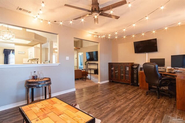 office area featuring rail lighting, ceiling fan with notable chandelier, dark hardwood / wood-style flooring, and a textured ceiling